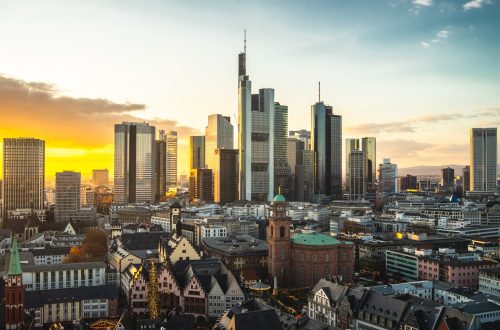 The Frankfurt city surrounded by buildings under a cloudy sky during a golden sunset in Germany